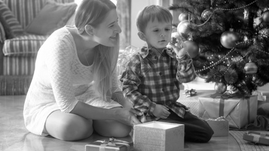 带着妈看圣诞礼物的男孩带着妈看圣诞礼物的男孩黑色和白画像图片