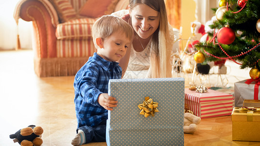 快乐的一家人与小男孩一起打开圣诞礼物快乐的一家人和小男孩起打开圣诞礼物图片