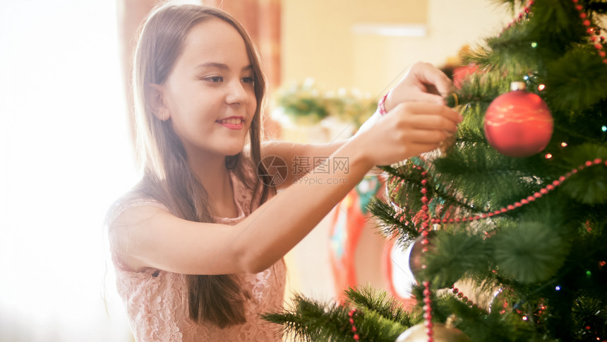 在客厅装饰圣诞树的长发白女孩图片
