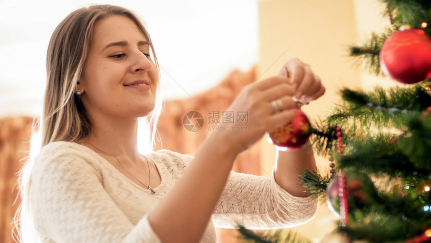 美丽的微笑着女士挂在圣诞树上的红子美丽微笑着女士肖像图片