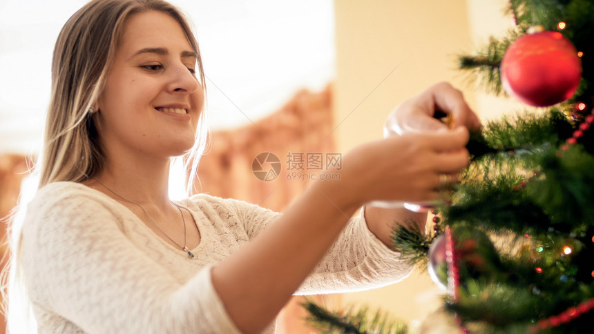 将圣诞树和珠子装饰的年轻女近镜肖像装饰成芭布和珠子的圣诞树年轻女子近像肖装饰成芭布和珠子的圣诞树年轻女子近像肖图片