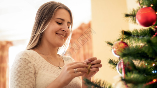 站在盛装圣诞树的美丽微笑女士肖像背景图片