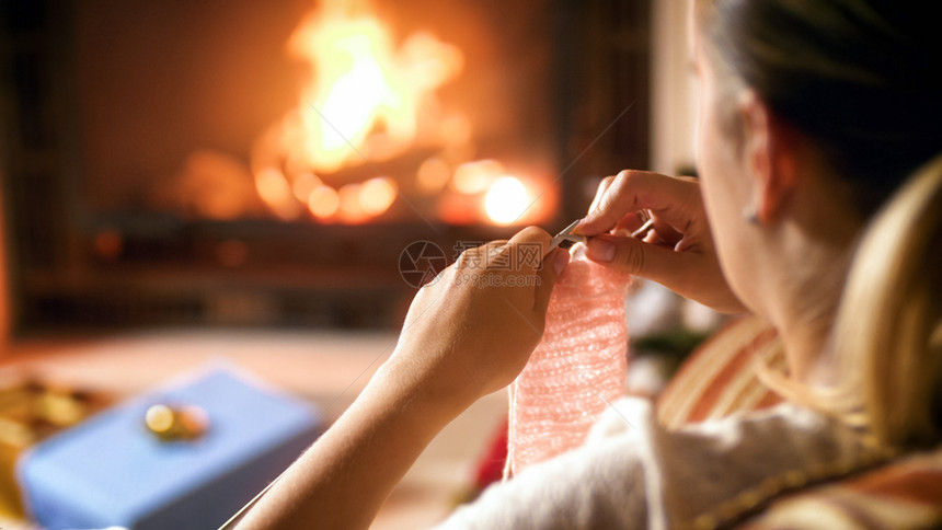 妇女夜间在壁炉旁编织的近视图像妇女夜间在壁炉边编织的近相照片图片
