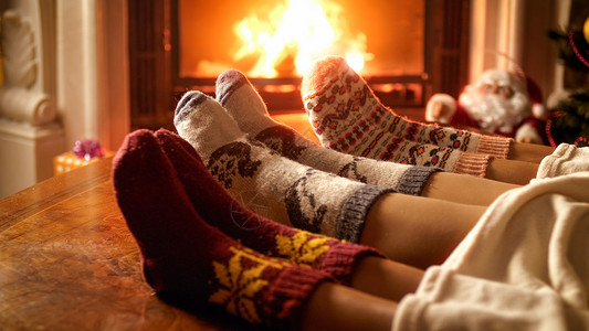 壁炉旁边的羊绒袜子家庭脚的近相照片图片