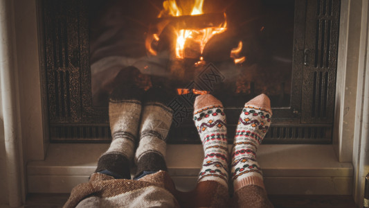 男女穿着羊毛袜子躺在壁炉旁睡的近相图片