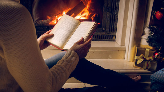 在圣诞节前夕壁炉边读书的年轻女子陶美照片图片