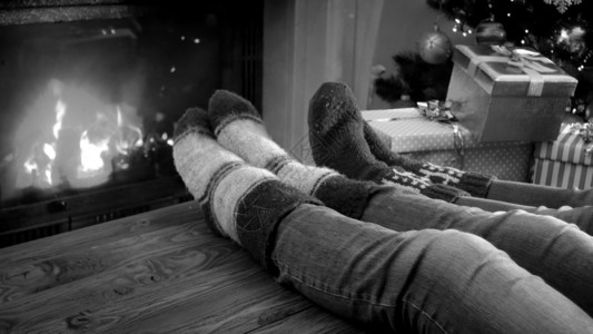 家庭在圣诞节前夕壁炉旁放松的黑色和白照片图片