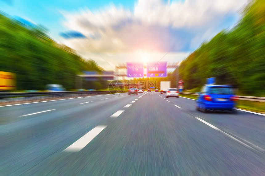 乘车驾驶高速公路日落时有交通和运动模糊效应图片