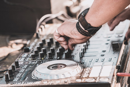 迷笛混音器DJ在数码中迪混音器控制上播放和混合音乐背景