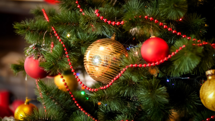 在圣诞树上挂着的红和金珠园地的近照图片
