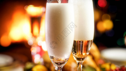 在晚上浪漫餐用香槟盛满两个杯子的特写照片图片