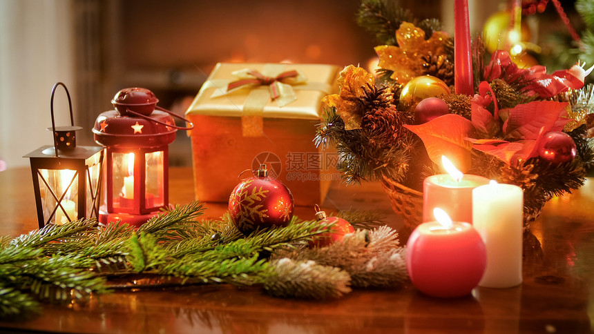圣诞花圈燃烧的蜡烛和木制桌上的礼品盒圣诞花圈燃烧的蜡烛和木制桌上的礼品盒图片