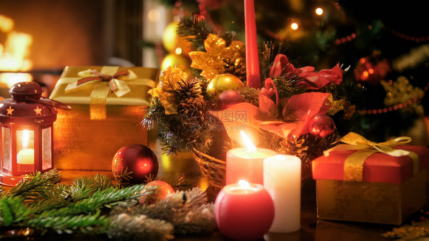 在传统花圈中对圣诞树和壁炉点燃蜡烛的紧贴照片图片