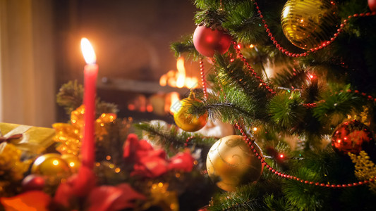 圣诞树枝对蜡烛和烧壁炉的紧贴照片圣诞树枝对蜡烛和烧壁炉的紧贴图像图片