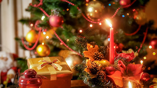 传统花环与礼物和蜡烛对抗装饰的圣诞树传统花环与礼物和蜡烛装饰的圣诞树近照背景图片