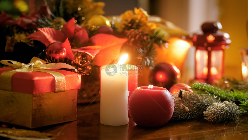 圣诞夜礼物盒和烧蜡烛的近照圣诞夜礼物盒和烧蜡烛的近照图片