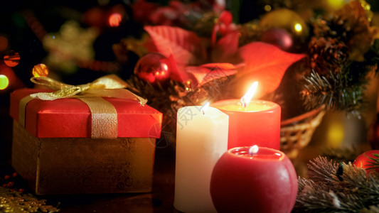 下个圣诞礼物和装饰花圈三支蜡烛的紧贴照片下个圣诞礼物和装饰花圈三支蜡烛的紧贴照片背景图片