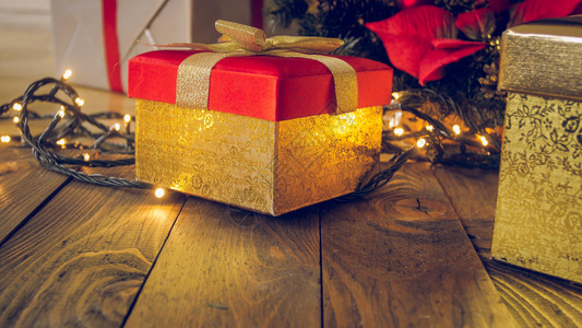 金盒的紧贴照片在木桌上配有礼品与圣诞灯对照图片