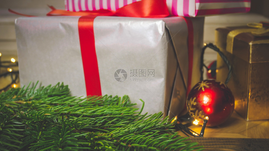 紧贴照片大礼品盒贴在紧靠圣诞节装饰品的木制餐桌旁贴在木制餐桌边贴在圣诞装饰品旁边贴上大礼品盒的图像图片