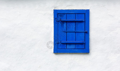 白墙背景上的蓝色旧窗头古董抽象壁纸图片