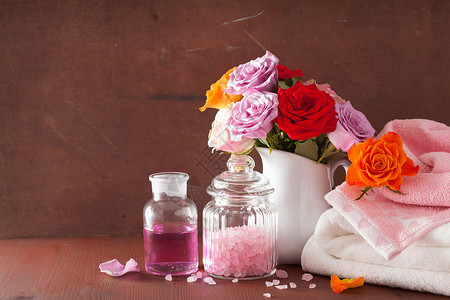 粉红色青蛙罐子用玫瑰花进行水疗并配有花基本食油盐背景