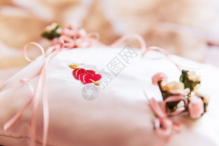 带红心形状的白色装饰枕头用于结婚戒指的宏观视图并有选择焦点效果图片