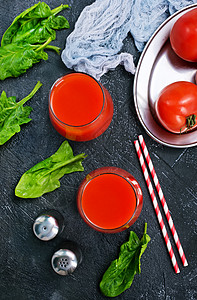 菠菜和西红柿番茄汁在玻璃和桌上背景