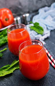 番茄汁在玻璃和桌上高清图片