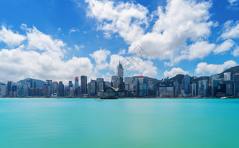 香港市中心天线和维多利亚港有蓝色的天空金融区和商业中心在智能城市技术概念摩天大楼和高层中午12点背景
