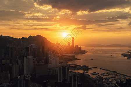 香港市区和维多利亚港的太阳下山智能城市的金融区高楼和天梯大日落时的空中景象背景图片