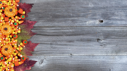 万圣节糖果和秋装饰的左边生锈木板图片
