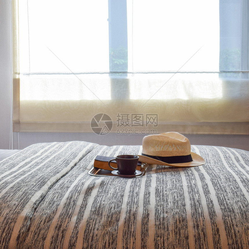 时髦的卧室内设计床边有带条纹的枕头和装饰桌灯图片