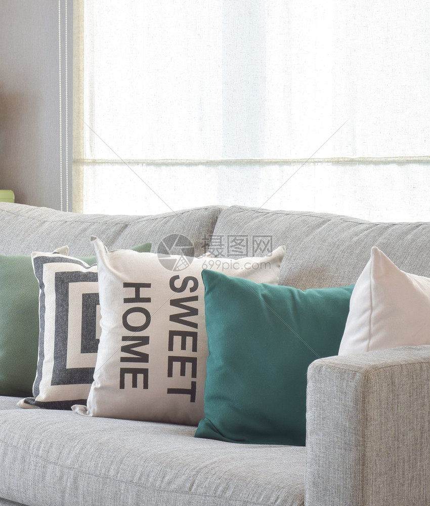 在现代客厅内带有几何型枕头的舒适灰色沙发和几何式枕头图片