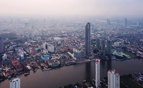 萨特霍恩ChaoPhrayaRiver和TaksinBridge在金融区和摩天大楼的曲线空中观察城市曼谷泰国日落时区背景