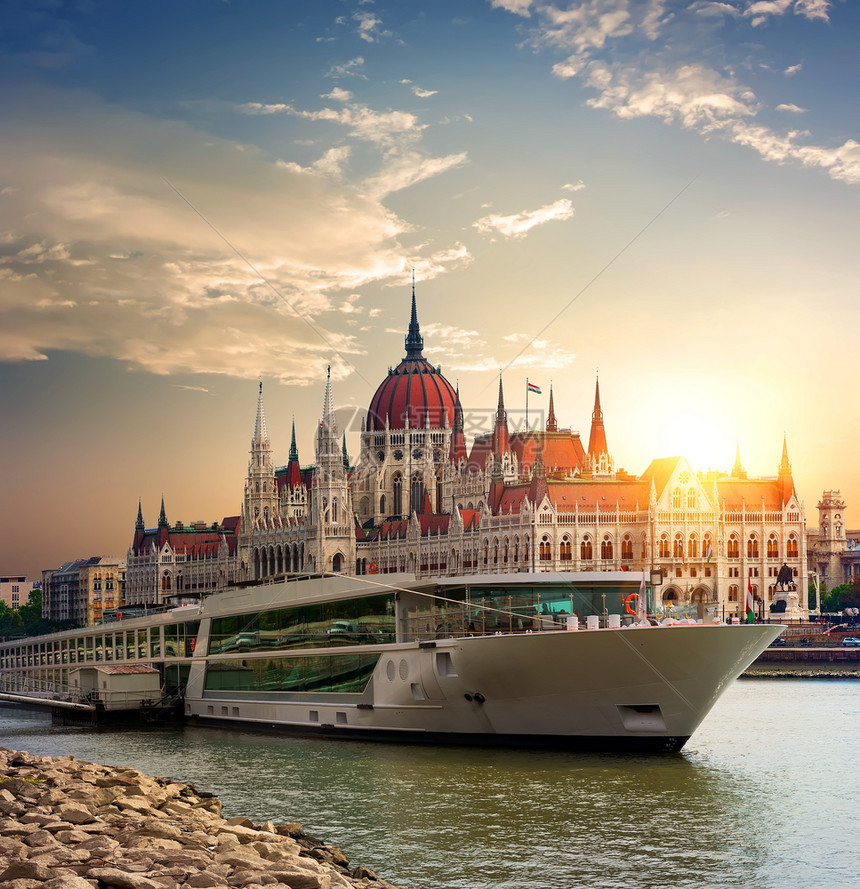 日落在匈牙利议会和多瑙河上旅游船空图片