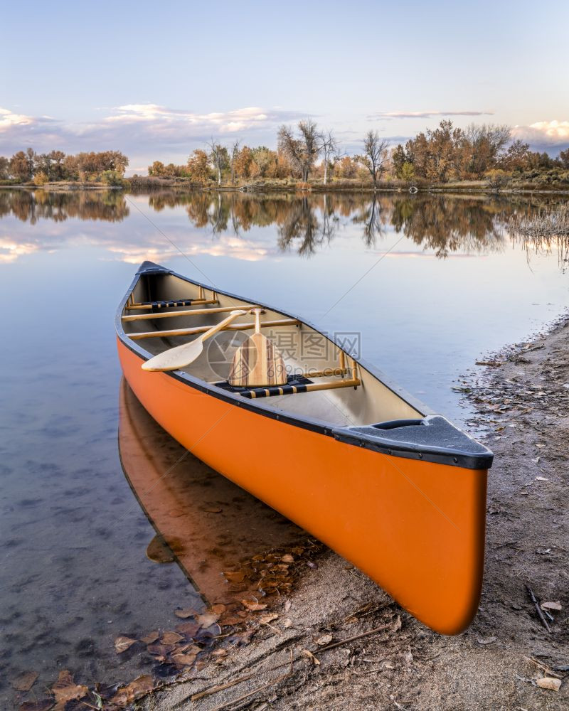在湖岸和瀑布风景的湖岸上用木板桨搭乘独舟图片