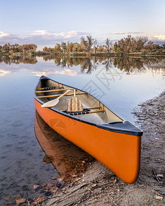 在湖岸和瀑布风景的湖岸上用木板桨搭乘独舟图片