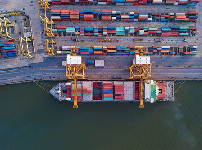 集装箱货轮在城市进出口业务和物流国际货进出口业务中的空最高视野由起重机将货物运往港口背景图片