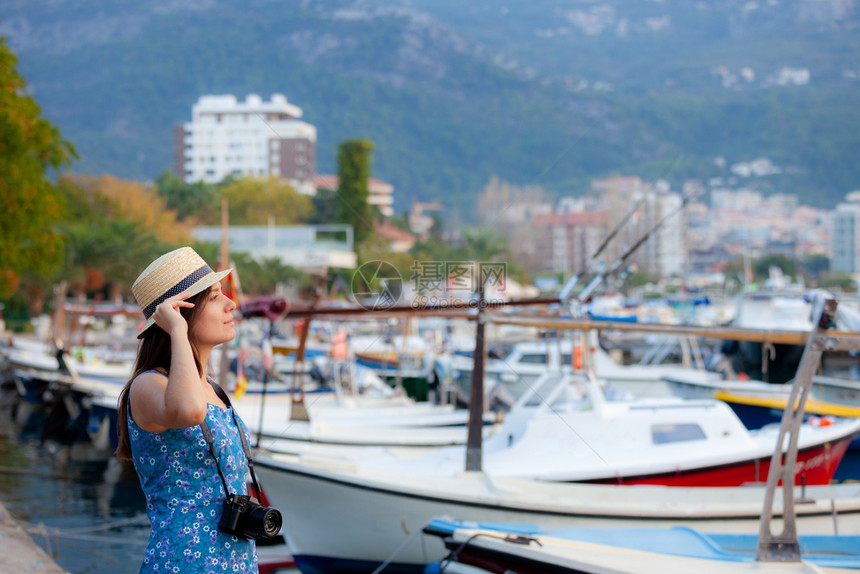 年轻有吸引力的快乐旅行女孩在旧地中海城市带着相机走在旧地中海城市图片