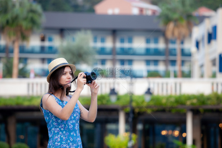 年轻有吸引力的快乐旅行女孩在旧地中海城市带着相机走在旧地中海城市图片
