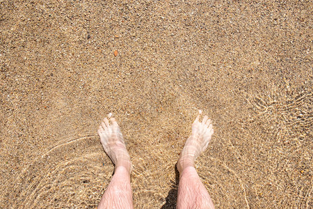 海滩上的脚水人腿顶端景色图片