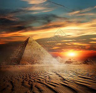 日落时沙漠中的埃及金字塔图片
