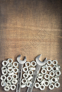 木制背景顶视图的扳手工具和金属坚果图片