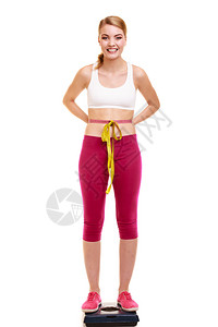 滑坡和体重减退快乐的年轻女孩以体重的磁带测量健康的生活方式概念孤立于白色快乐的女士体重测量背景图片