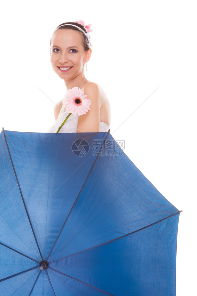 带着蓝色雨伞和格贝拉花的白裙子微笑着迷人的漂亮新娘欢笑着的年轻女孩在下雨的婚礼日中微笑着她被孤立在白色背景中欢笑着的新娘拿雨伞和图片