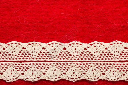 红纺织品背景上的白色旧带子图片