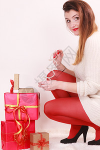 穿着高跟鞋的女子红丝袜许多礼物将手镯放在盒中圣诞节庆祝概念图片