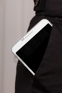 装在裤子口袋移动电话商业服饰中的智能手机装在裤子口袋显示器中的移动电话背景图片