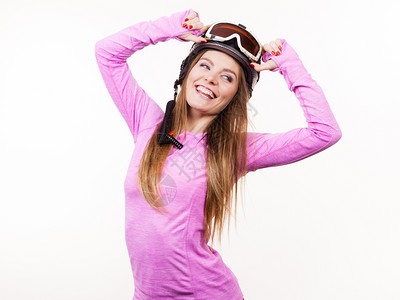 冬季运动爱好者概念戴运动头盔的女人穿粉色衣服的年轻女士背景图片
