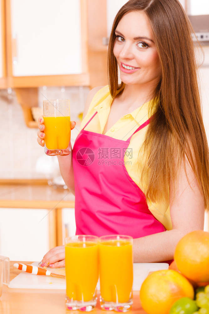 在家厨房的年轻女庭主妇喝着新鲜自制橙汁饮料健康食素减肥和人的概念图片